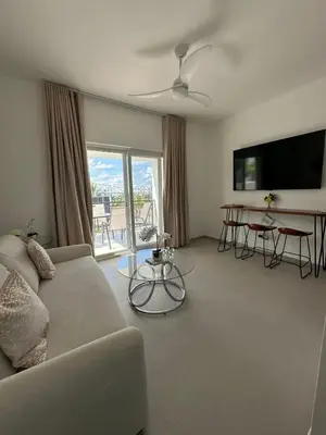 a living room with a couch and a flat screen tv at Esprit Caribbean Bayahibe in Bayahibe