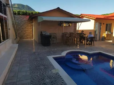 a backyard with a swimming pool and a house at Villa Bellevue in San Felipe de Puerto Plata