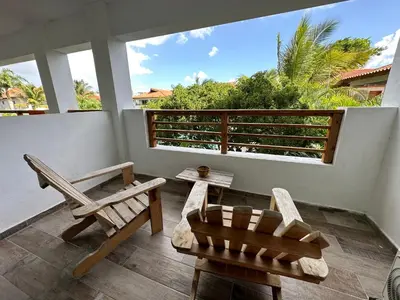 a room with chairs and a balcony with a view at Paraíso Bayahibe in Bayahibe