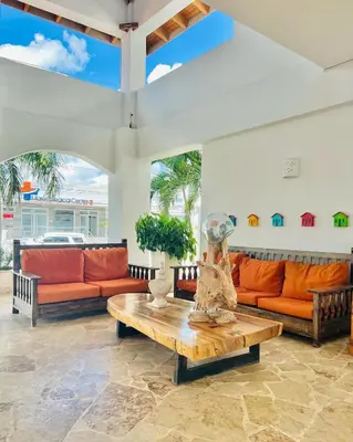 a living room with orange couches and a table at Paraíso Bayahibe in Bayahibe