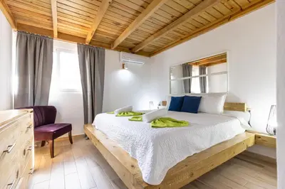 a bedroom with a large bed and a purple chair at Paraíso Bayahibe in Bayahibe
