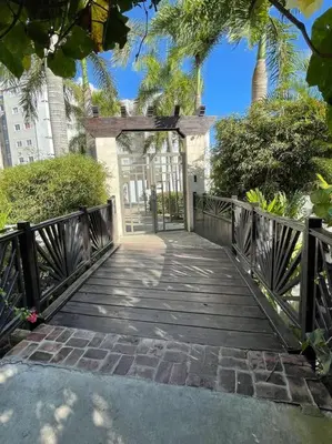 a wooden walkway leading to a building with a gate at Mountain View Cibao in Santiago de los Caballeros