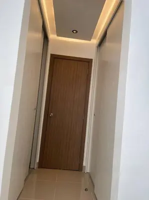a hallway with a wooden door in a building at Mountain View Cibao in Santiago de los Caballeros