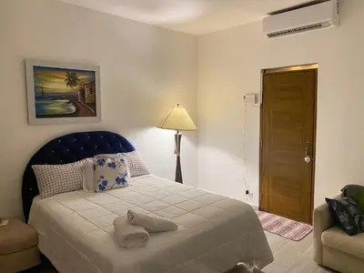 a bedroom with a bed with a blue head board at Only Room By Merengue House, 8 minutos airport in Monte Adentro