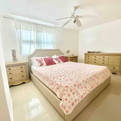 a bedroom with a bed and two dressers and a fan at 3 Bedrooms At Marbella Beachfront Juan Dolio no820 in Juan Dolio