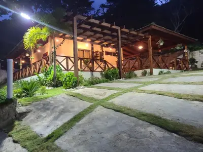 a house with a wooden roof at night at Villa Zarina - Polo Barahona in Polo
