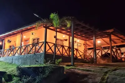 a house at night with a palm tree in front at Villa Zarina - Polo Barahona in Polo