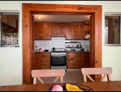 a kitchen with wooden cabinets and a stove at Villa Zarina - Polo Barahona in Polo