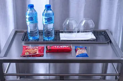 a table with two bottles of water and snacks on it at Escape Penthouse near Blue Mall - 4BR with Private Rooftop & City Views in Santo Domingo