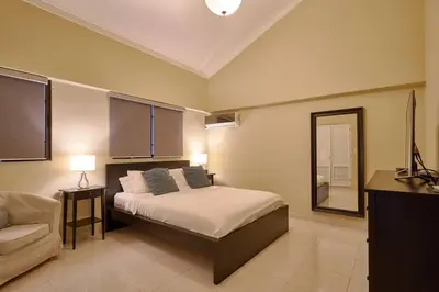 a bedroom with a bed and a chair in it at Escape Penthouse near Blue Mall - 4BR with Private Rooftop & City Views in Santo Domingo