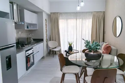 a kitchen and living room with a glass table and chairs at Brickell Apart Hotel in Santo Domingo