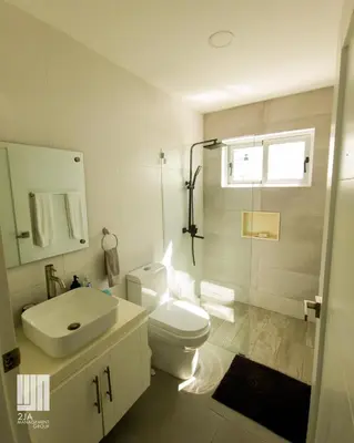 a bathroom with a toilet and a sink and a shower at 2JA Management Group - SOV Properties in Sosúa