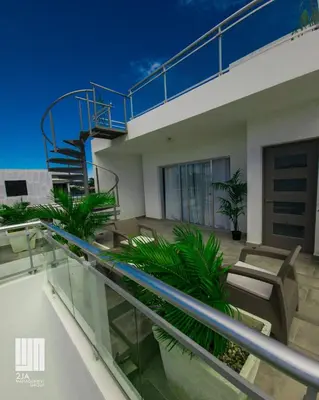 a balcony of a house with a spiral staircase at 2JA Management Group - SOV Properties in Sosúa