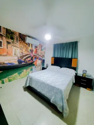 a bedroom with a bed and a painting of a canal at The apartment you dreamed of 1 in Santiago de los Caballeros