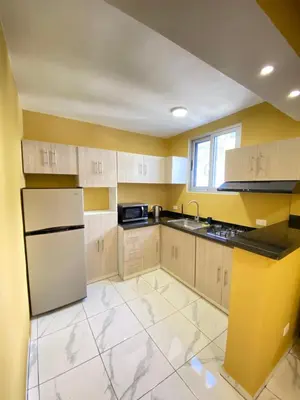 a kitchen with white appliances and yellow walls at Hotel Checo Sosúa in Sosúa