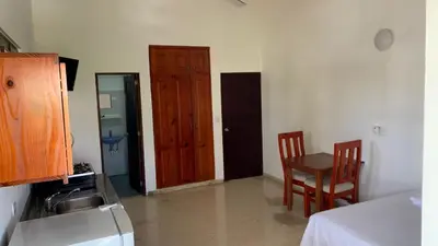 a kitchen with a table and two chairs and a door at Hotel Checo Sosúa in Sosúa