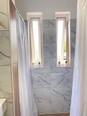a bathroom with two windows and a marble wall at Esmeralda67 Tamarindo in Bayahibe