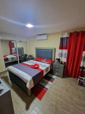 a bedroom with a large bed with red pillows at Villa vacacional Rikheriluz in La Romana
