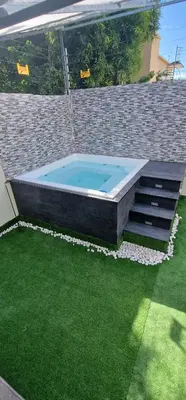 a swimming pool in a backyard with green grass at Villa vacacional Rikheriluz in La Romana
