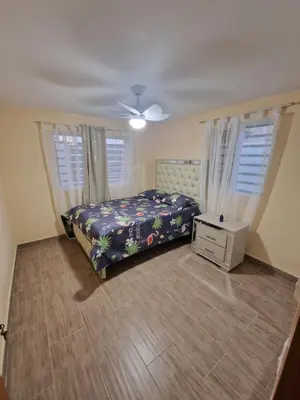 a bedroom with a bed and two windows at Villa vacacional Rikheriluz in La Romana