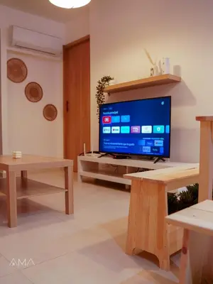 a living room with a large television and wooden tables at Acogedor Apartamento Céntrico in Santo Domingo