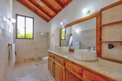 a bathroom with two sinks and a toilet at Río Mar Cumayasa in La Romana