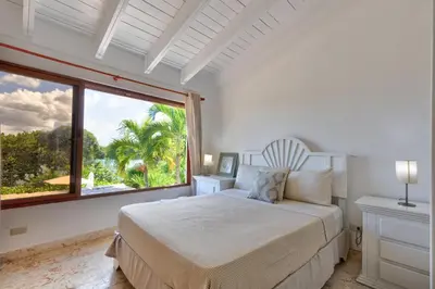 a bedroom with a bed and a large window at Río Mar Cumayasa in La Romana