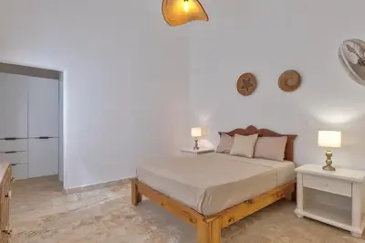 a white bedroom with a bed and two night stands at Río Mar Cumayasa in La Romana