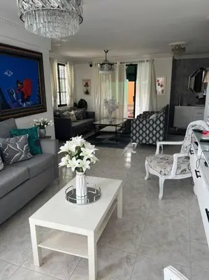 a living room with a couch and a table with flowers at Malecon View, Zona Colonial in Santo Domingo