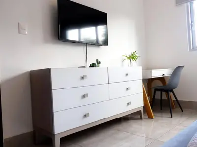 a bedroom with a dresser with a tv on the wall at Dreams Room Soha II in Santiago de los Caballeros