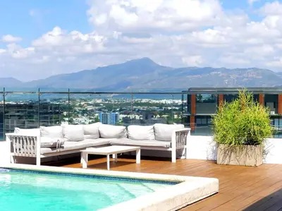 a white couch sitting on a deck next to a swimming pool at Dreams Room Soha II in Santiago de los Caballeros