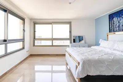 a bedroom with a large bed and two windows at Gateway For You And Your Loves Ones I Sleeps 6 in Santo Domingo