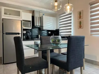 a kitchen with a table and chairs and a refrigerator at Suites Room Soha II in Santiago de los Caballeros