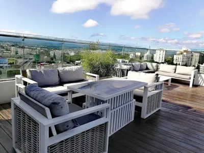 a patio with a table and chairs on a balcony at Suites Room Soha II in Santiago de los Caballeros