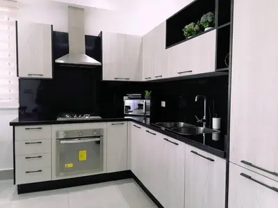a kitchen with white cabinets and a sink at Paradise Room Rialto Residences in Santiago de los Caballeros