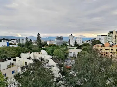 a view of a city with tall buildings and trees at Paradise Room Rialto Residences in Santiago de los Caballeros