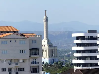 a building with a tower in front of a building at Paradise Room Rialto Residences in Santiago de los Caballeros