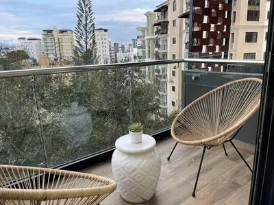 a balcony with two chairs and a vase on it at Paradise Room Rialto Residences in Santiago de los Caballeros