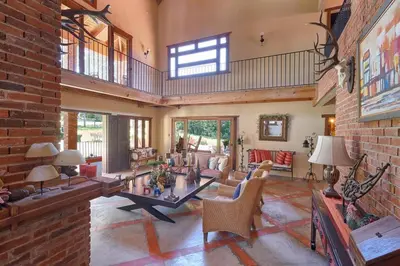 a large living room with a brick wall at Escape Chalet at Pinar del Sol in Jarabacoa in Jarabacoa