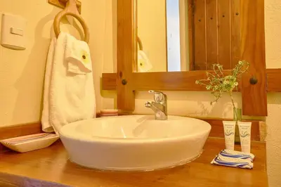a bathroom with a white sink and a mirror at Escape Chalet at Pinar del Sol in Jarabacoa in Jarabacoa