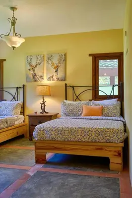 a bedroom with two beds and a lamp and a window at Escape Chalet at Pinar del Sol in Jarabacoa in Jarabacoa