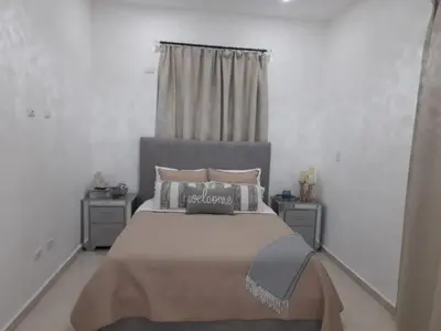 a bedroom with a large bed and two night stands at Villa Mónaco Jarabacoa RD in Jarabacoa