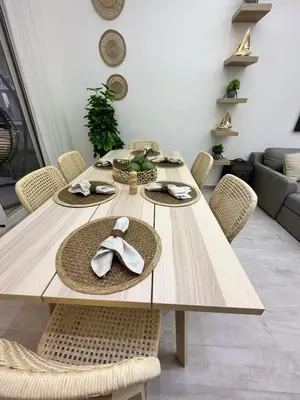 a wooden dining table with straw hats and chairs at LUXURY CONDO Cana Bay 1 CLUB BEACH in Punta Cana