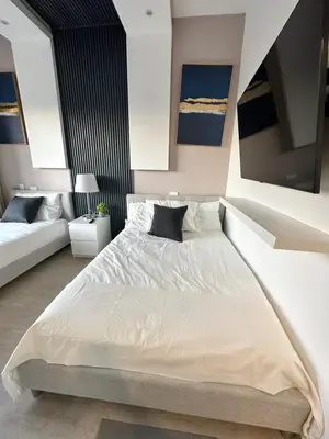 a bedroom with a large white bed and a couch at LUXURY CONDO Cana Bay 1 CLUB BEACH in Punta Cana