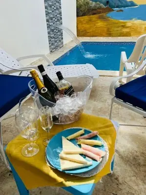 a table with a plate of cheese and bottles of wine at Complejo girasol in Santo Domingo