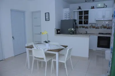 a kitchen with a table with white chairs and a counter at Complejo Giraflor in Pantoja