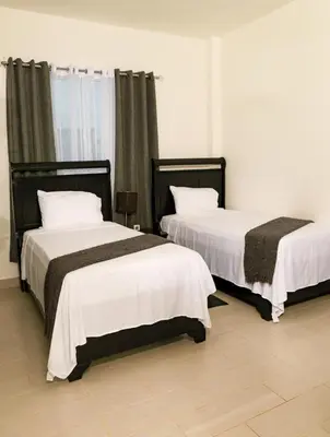 two beds sitting in a room withskirts at The White Rock Hotel B&B in Los Conucos