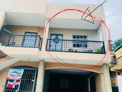 a white building with a balcony on the side of it at J&W apartment in San Felipe de Puerto Plata