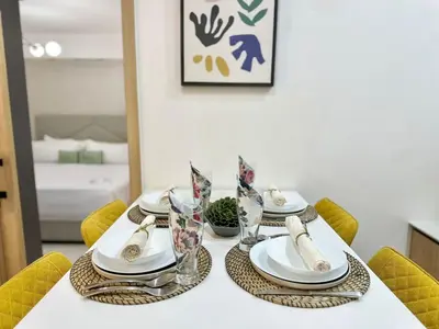 a dining room table with plates and glasses on it at Confort y estilo en Galería 360 con piscina y gimnasio in Santo Domingo