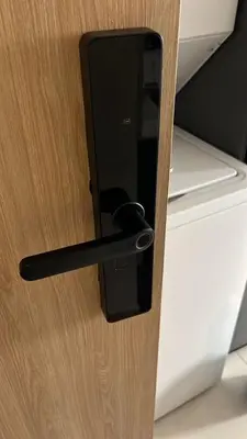 a wooden door with a black door handle at Confort y estilo en Galería 360 con piscina y gimnasio in Santo Domingo